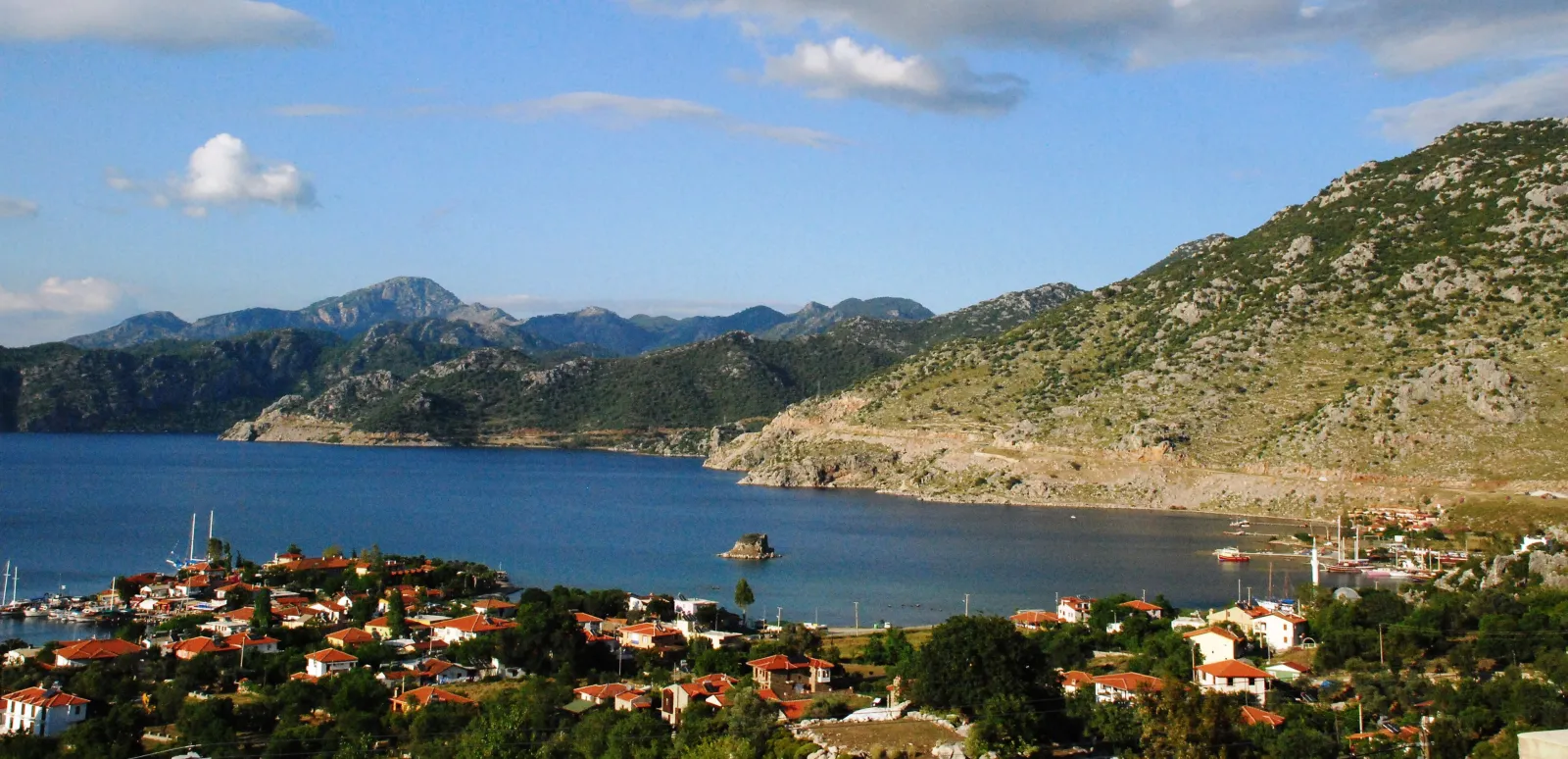 Selimiye köyü, kırmızı çatılı evler, sakin koy ve arkadaki dağlar