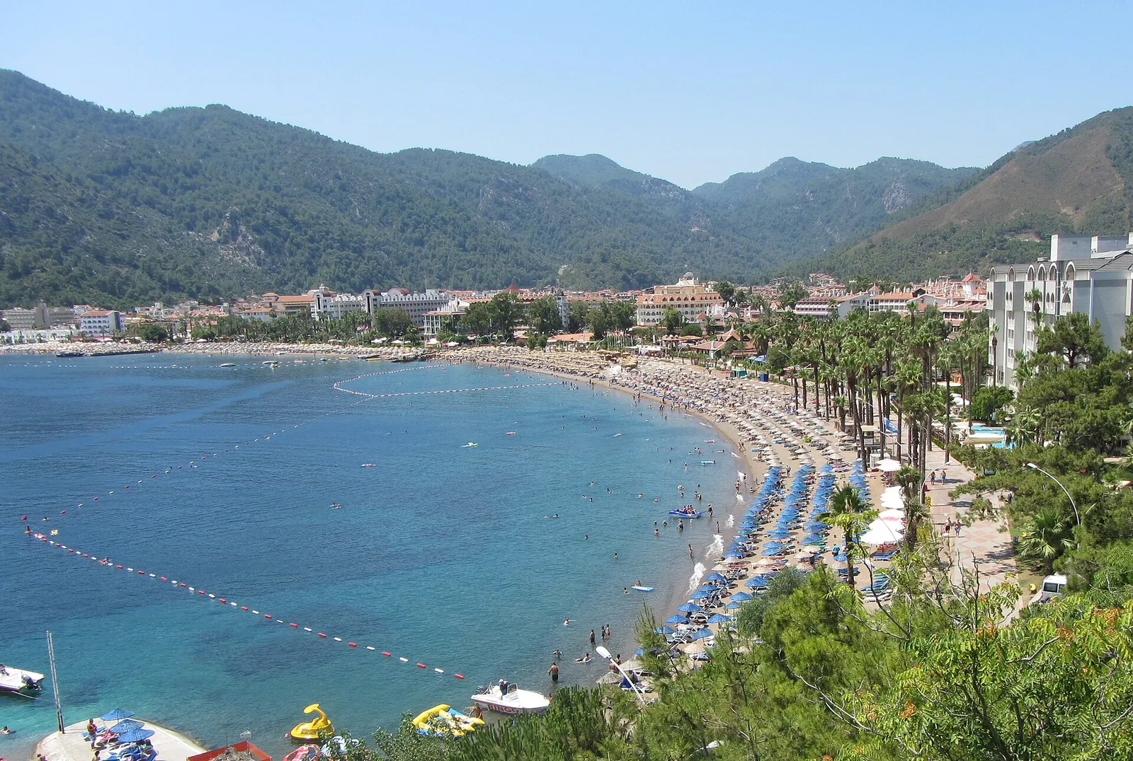 Marmaris koyu, palmiyeli sahil şeridi ve çam ormanlı dağlar